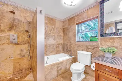 a bathroom with a toilet and a tub and a sink at Steps to Beach, Pool, Backyard Oasis, Game Room in Fort Lauderdale