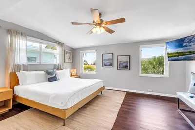 a bedroom with a bed and a ceiling fan at Steps to Beach, Pool, Backyard Oasis, Game Room in Fort Lauderdale