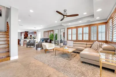 a living room with a couch and a ceiling fan at Steps to Beach, Pool, Backyard Oasis, Game Room in Fort Lauderdale
