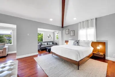 a bedroom with a bed and a living room at Steps to Beach, Pool, Backyard Oasis, Game Room in Fort Lauderdale