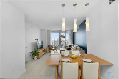 a dining room and living room with a table and chairs at Amazing Pool Infinity View and Gym in Hallandale Beach
