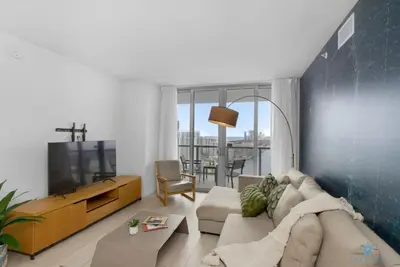 a living room with a couch and a tv at Amazing Pool Infinity View and Gym in Hallandale Beach