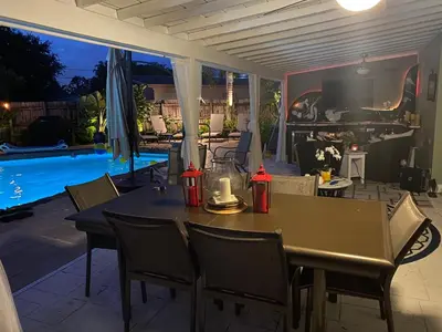a patio with a table and chairs and a pool at Wilton Manors A Mens Oasis in Fort Lauderdale