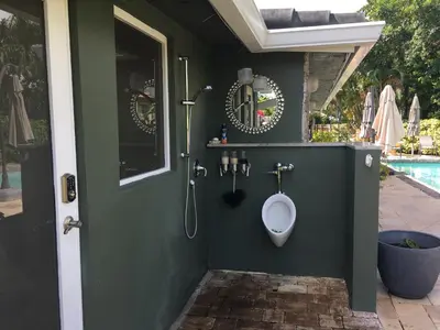 a bathroom with a urinal next to a pool at Wilton Manors A Mens Oasis in Fort Lauderdale
