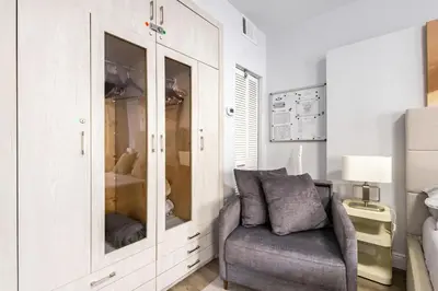 a living room with a chair and a cabinet at Luxe ocean drive condo in miami south beach in Miami Beach