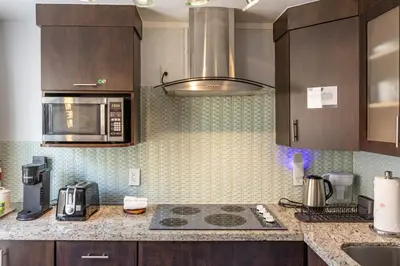 a kitchen with wooden cabinets and a stove top oven at Luxe ocean drive condo in miami south beach in Miami Beach
