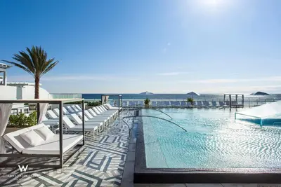 a swimming pool with white lounge chairs and the ocean at Stylish 1BR Suite with 5 Star Amenities and Stunning Views in Fort Lauderdale