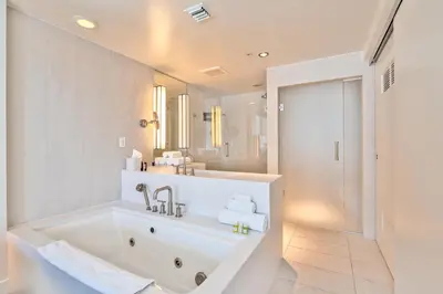 a white bathroom with a tub and a sink at Stylish 1BR Suite with 5 Star Amenities and Stunning Views in Fort Lauderdale