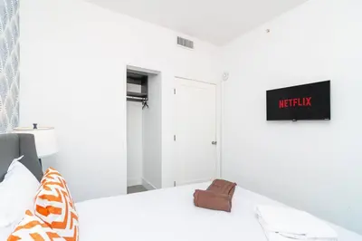 a white bedroom with a bed with a towel on it at Cozy Miami 2BR Oasis Near Brickell, Calle Ocho & Marlins Stadium in Miami