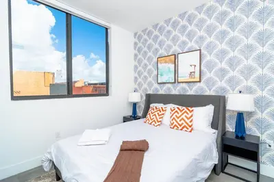 a bedroom with a white bed and a large window at Cozy Miami 2BR Oasis Near Brickell, Calle Ocho & Marlins Stadium in Miami
