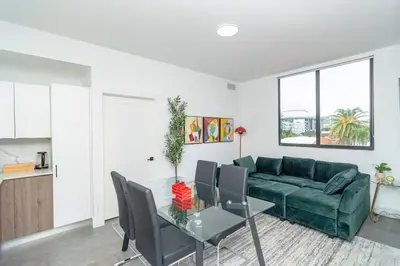 a living room with a green couch and a table at Modern Cozy 2BR Oasis with King Beds Near Marlins Park & Brickell in Miami