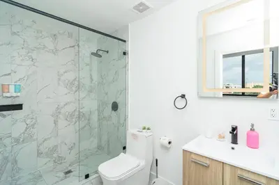 a bathroom with a shower and a toilet and a sink at Modern Cozy 2BR Oasis with King Beds Near Marlins Park & Brickell in Miami