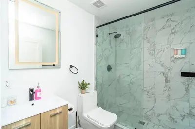 a bathroom with a shower with a toilet and a sink at Bright 1BR with Netflix and King Bed Near Brickell and Marlins Park in Miami