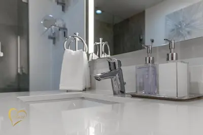a bathroom counter with a sink and a mirror at Lumiére Penthouse in Miami