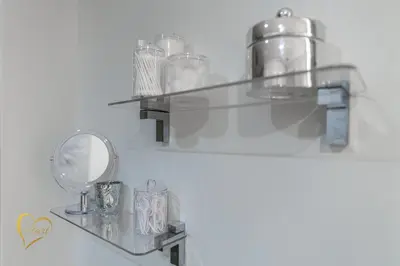 a glass shelf with dishes and a mirror on a wall at Lumiére Penthouse in Miami