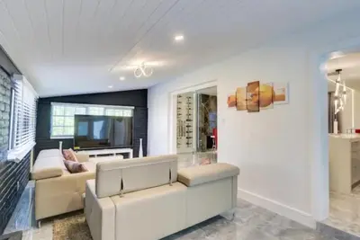 a living room with a couch and a tv at Flamingo House with Cinema, Pool & Chill Area in Miami