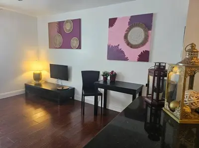 a living room with a table and a desk with a television at Great 1BedRoom RENOVATED 1 minute from the BEACH in Miami Beach