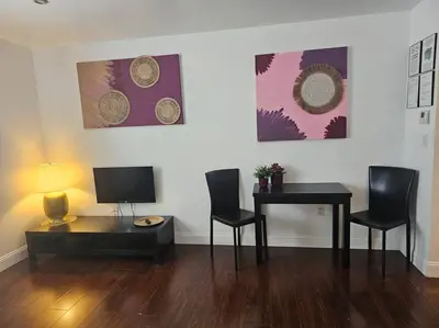 a living room with a table and chairs and a television at Great 1BedRoom RENOVATED 1 minute from the BEACH in Miami Beach