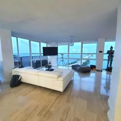 a living room with a white couch in a room with windows at Penthouse 2 stroy 2 bedroom water views to share in Miami