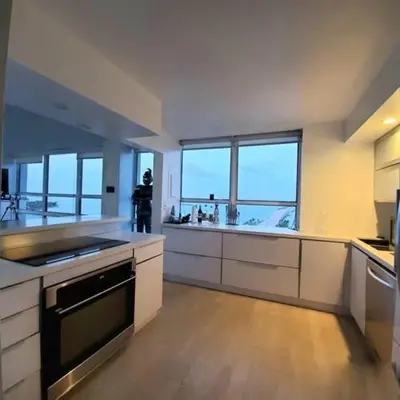 a large kitchen with white counters and windows at Penthouse 2 stroy 2 bedroom water views to share in Miami