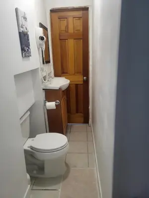a bathroom with a toilet and a wooden door at Azucar Miami in Miami