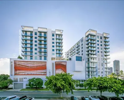 two tall buildings with cars parked in a parking lot at Luxury & Modern Condo in Design District with Pool in Miami