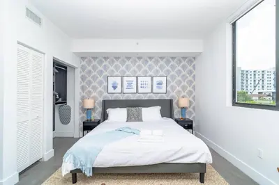 a white bedroom with a bed and two windows at Cozy and Comfortable 1BR Near Calle Ocho and Brickell in Miami
