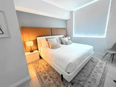 a bedroom with a white bed and a chair at Elegant Condo 2BR w Beautiful City Views in Miami