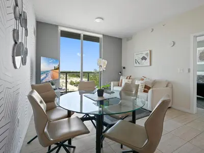 a dining room with a glass table and chairs at Elegant Condo 2BR w Beautiful City Views in Miami