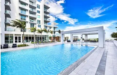 a large swimming pool in front of a building at Elegant Condo 2BR w Beautiful City Views in Miami