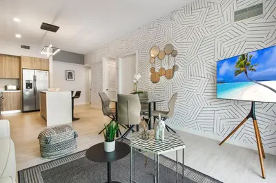 a living room with a table and a tv on a wall at Elegant Condo 2BR w Beautiful City Views in Miami