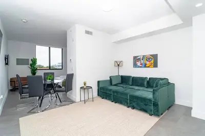 a living room with a green couch and a table at Central 1BR in Miami with King Bed Near Wynwood and Marlins Park in Miami