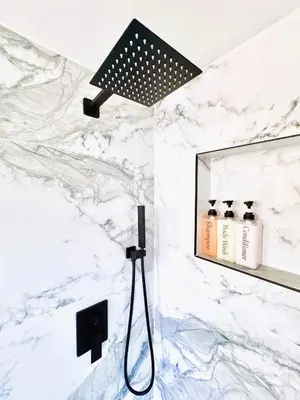 a shower in a bathroom with a white marble wall at Homey Haven in Vibrant South Beach in Miami Beach