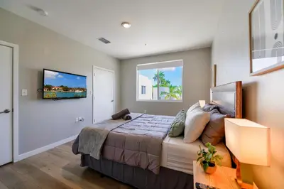 a bedroom with a bed and a tv on a wall at Spacious 3BR Townhouse with Free Parking Included! in Miami