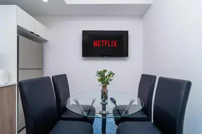 a dining room with a glass table and blue chairs at Beautiful 1BR in Little Havana Close with King Bed Near Brickell & Marlins Park in Miami