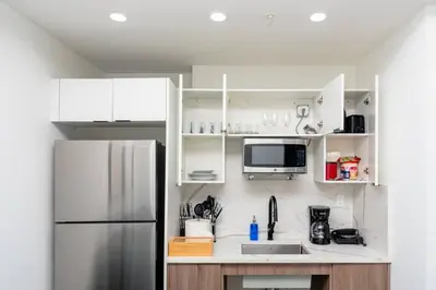 a kitchen with white cabinets and a refrigerator at Relaxing 1BR in Miami Close to Brickell and South Beach in Miami