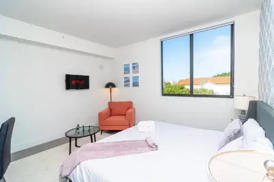 a bedroom with a bed and a chair and a window at Relaxing 1BR in Miami Close to Brickell and South Beach in Miami