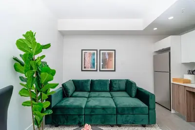 a green couch in a living room with a kitchen at Relaxing 1BR in Miami Close to Brickell and South Beach in Miami