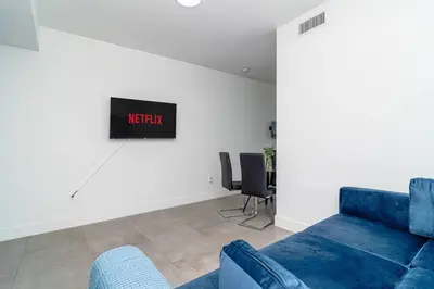 a living room with a blue couch and a tv at Centrally Located 1BR with King Bed Near Brickell, Airport Downtown and Wynwood in Miami