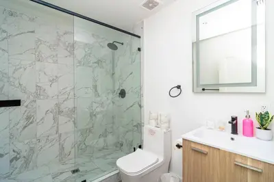 a bathroom with a shower and a toilet and a sink at Well Located 1BR with King Bed, Laundry and Parking Option Near Brickell and Marlins Park in Miami