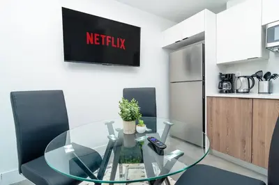 a glass table in a kitchen with two black chairs at Miami 1BR New Oasis with King Bed Near Brickell & Marlins Park in Miami