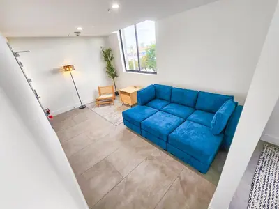 a living room with a blue couch and a table at Miami 2BR Getaway with King Beds Near Marlins Park & Calle Ocho in Miami