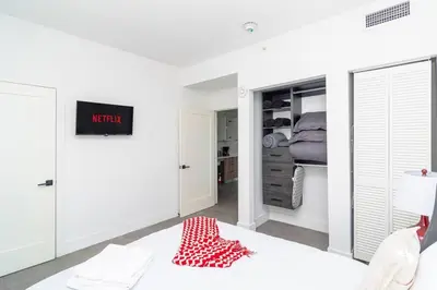 a white bedroom with a bed and a closet at Miami 2BR Getaway with King Beds Near Marlins Park & Calle Ocho in Miami