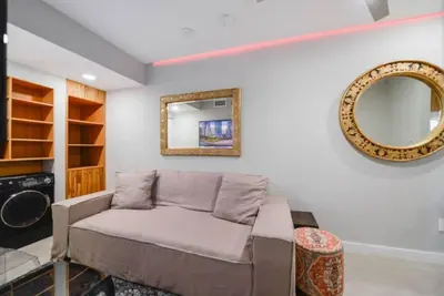 a living room with a couch and a mirror at Anselmo Brickell Apartments in Miami
