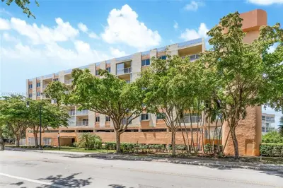 an apartment building with trees in front of a street at Skyline Paradise in Sunny Isles Beach in Sunny Isles Beach