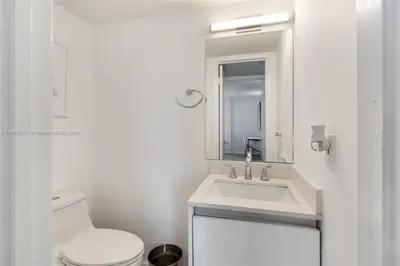 a white bathroom with a sink and a toilet at Skyline Paradise in Sunny Isles Beach in Sunny Isles Beach