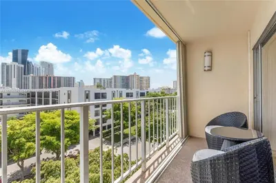 a balcony with chairs and a view of the city at Skyline Paradise in Sunny Isles Beach in Sunny Isles Beach
