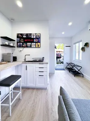 a kitchen with white cabinets and a sink and a table at Quiet Shenandoah Retreat, Central Miami in Miami