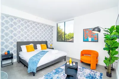 a bedroom with a bed and an orange chair at Luxury Studio Suite with King Bed Near Brickell & Marlins Park in Miami