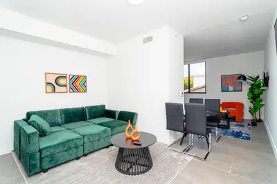a living room with a green couch and a table at Luxury Studio Suite with King Bed Near Brickell & Marlins Park in Miami
